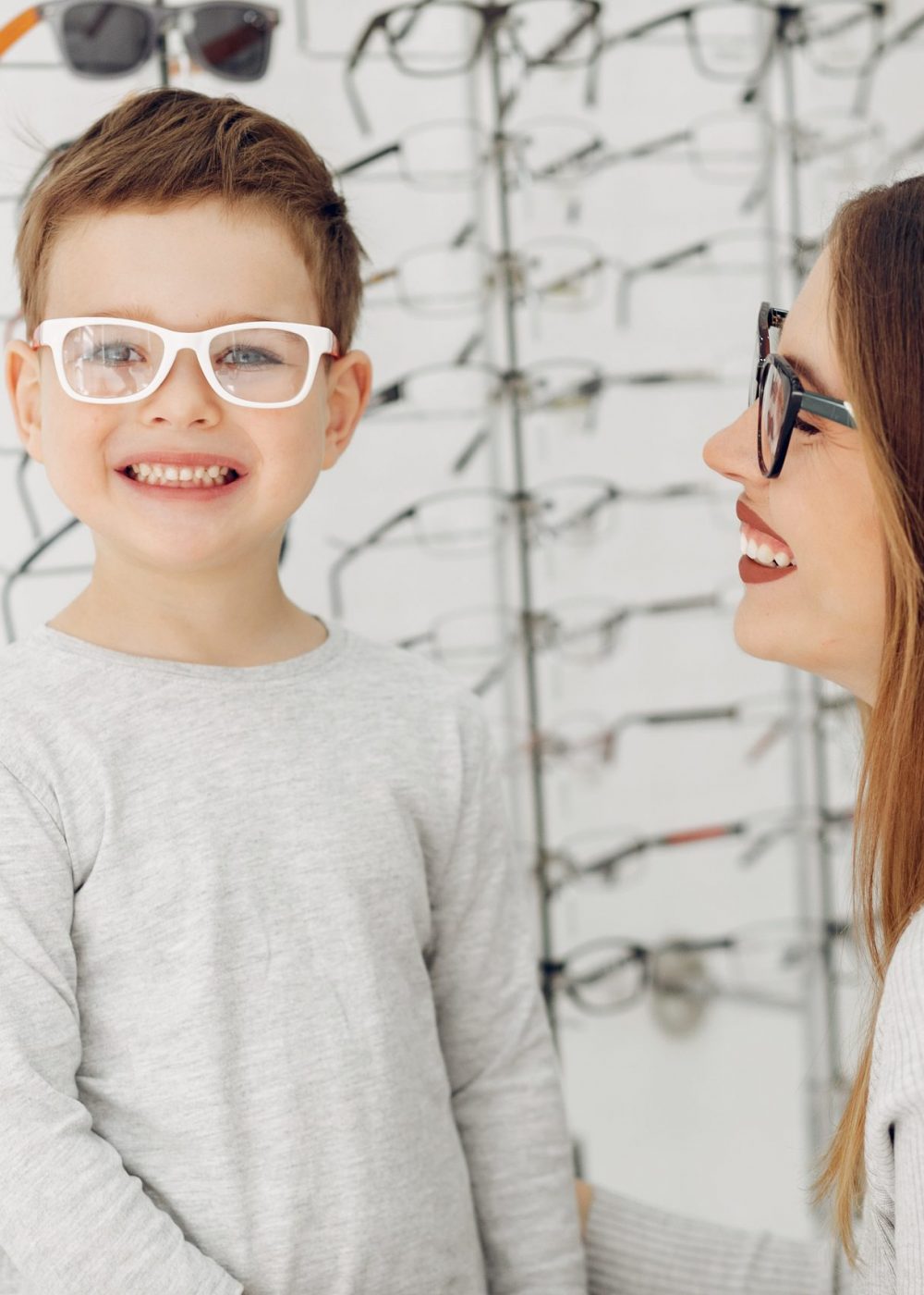 Mother with cute son. Family buy glasses